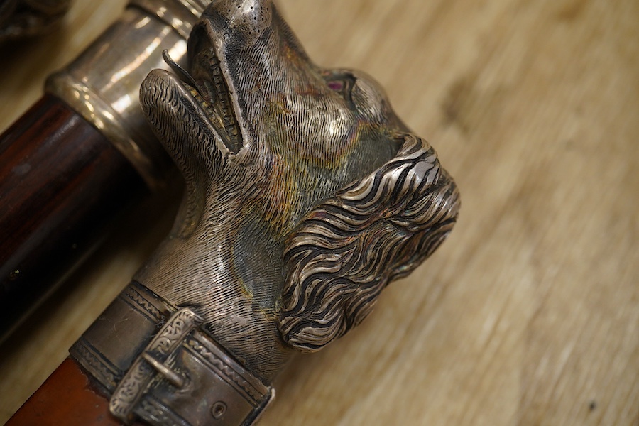 Three 19th century walking sticks, two with silver tops to include a dogs head example, one with unmarked embossed white metal top, largest 97cm in length